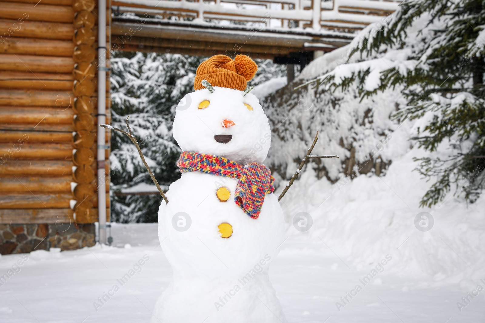 Photo of Funny snowman with hat and scarf outdoors. Winter vacation