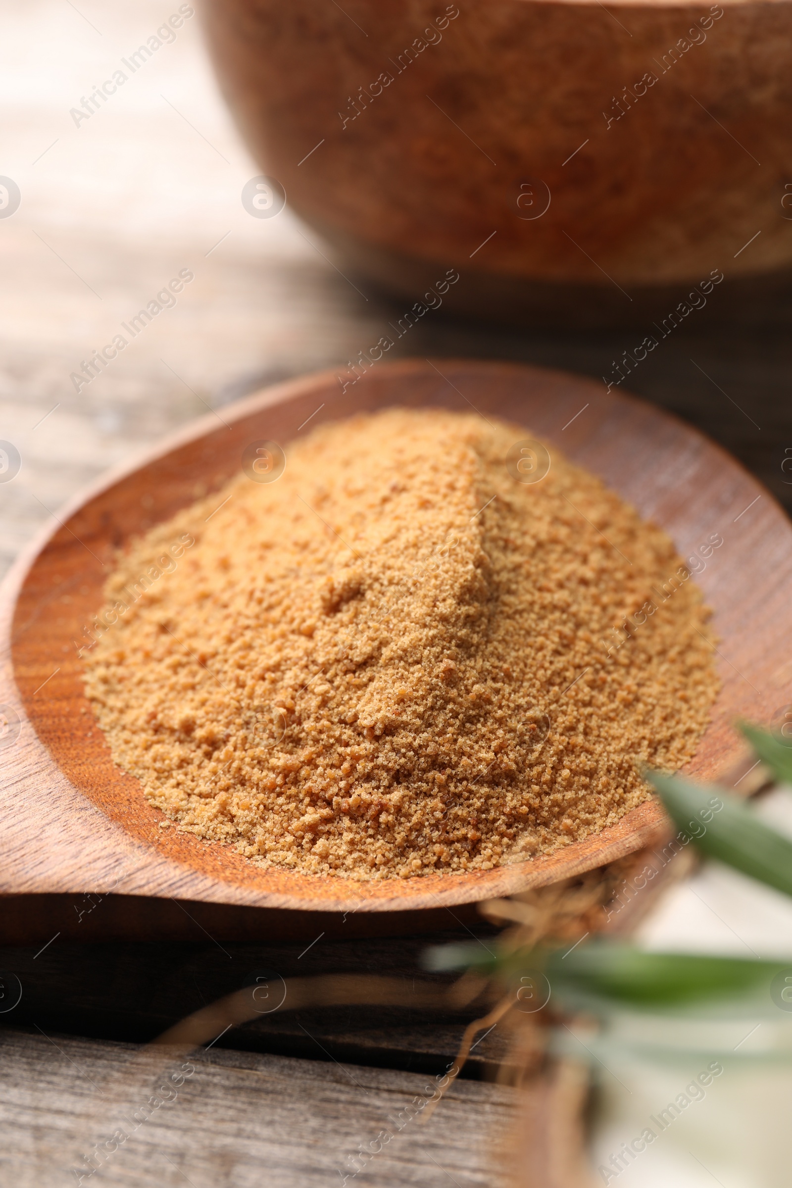 Photo of Spoon with coconut sugar on wooden table, closeup