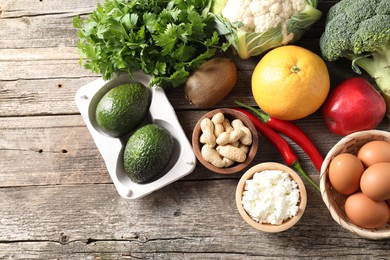 Healthy meal. Different vegetables and raw eggs on wooden table, flat lay