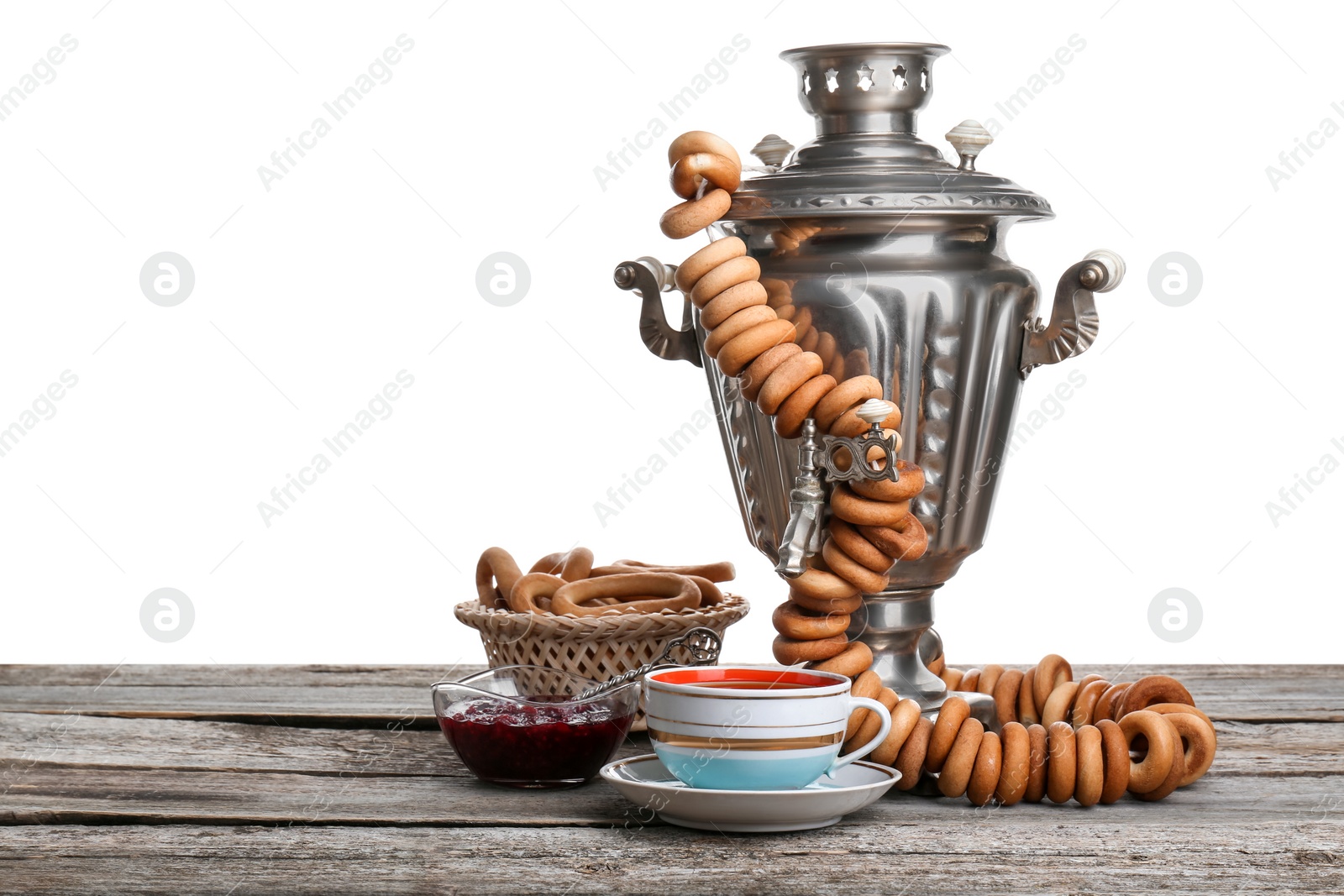 Photo of Composition with hot tea and delicious ring shaped Sushki (dry bagels) on wooden table against white background, space for text