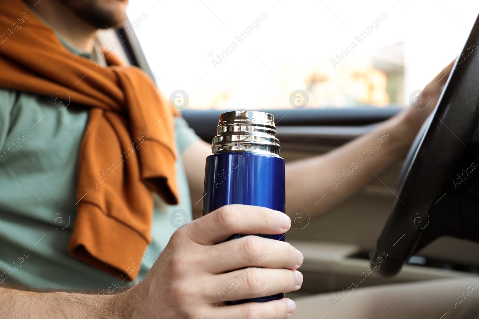 Photo of Man with thermos driving car, closeup view