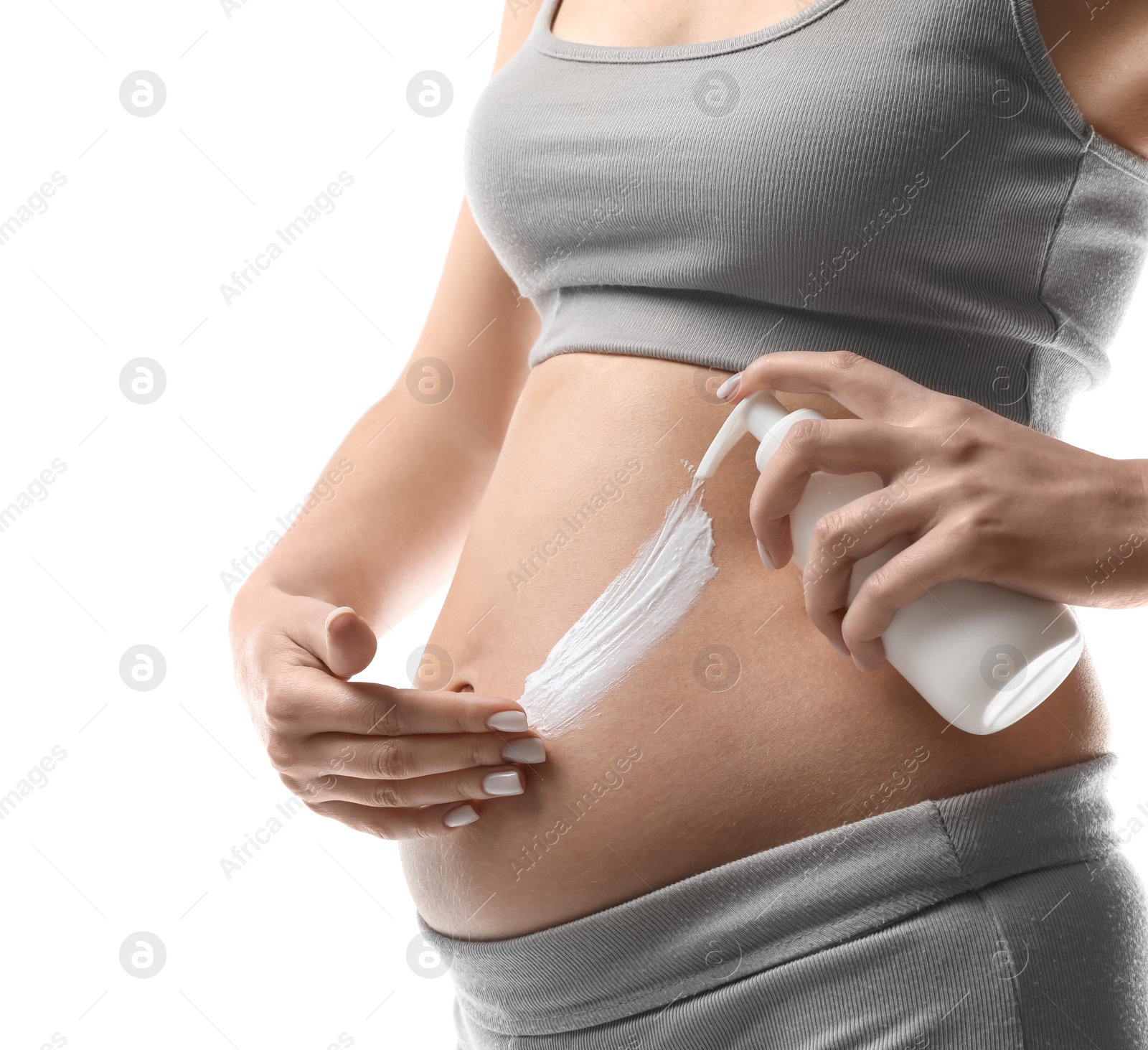 Photo of Pregnant woman applying cosmetic product on belly against white background, closeup