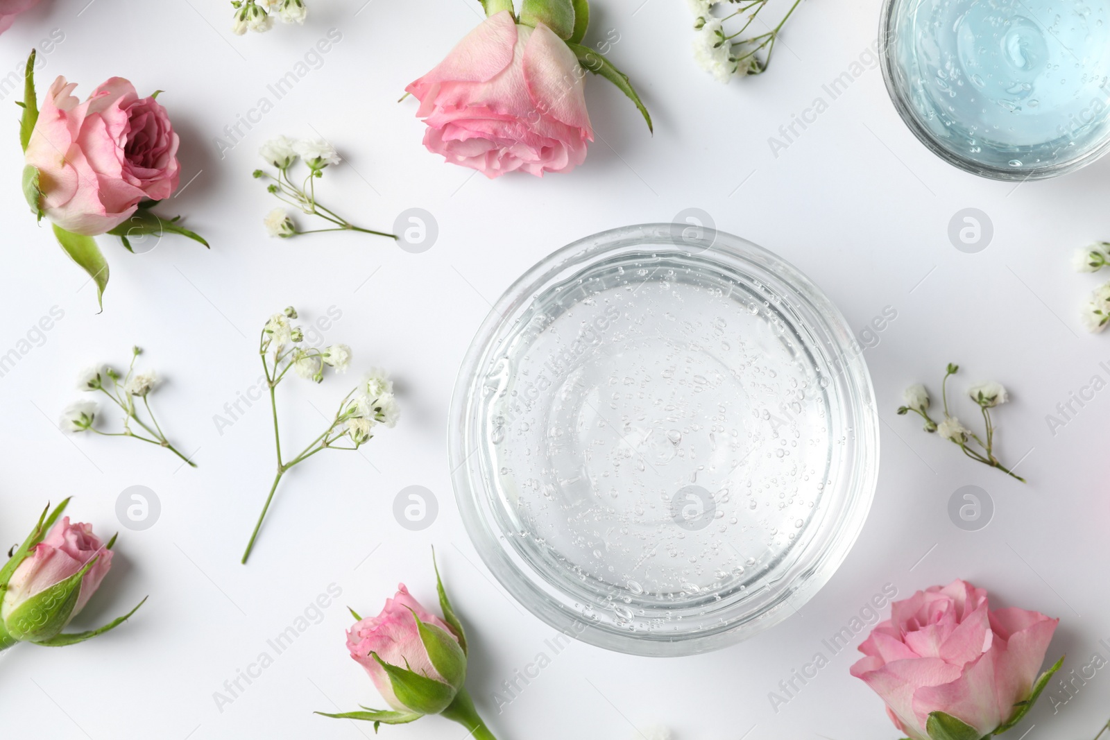 Photo of Composition with cosmetic gel and beautiful flowers on white background, top view