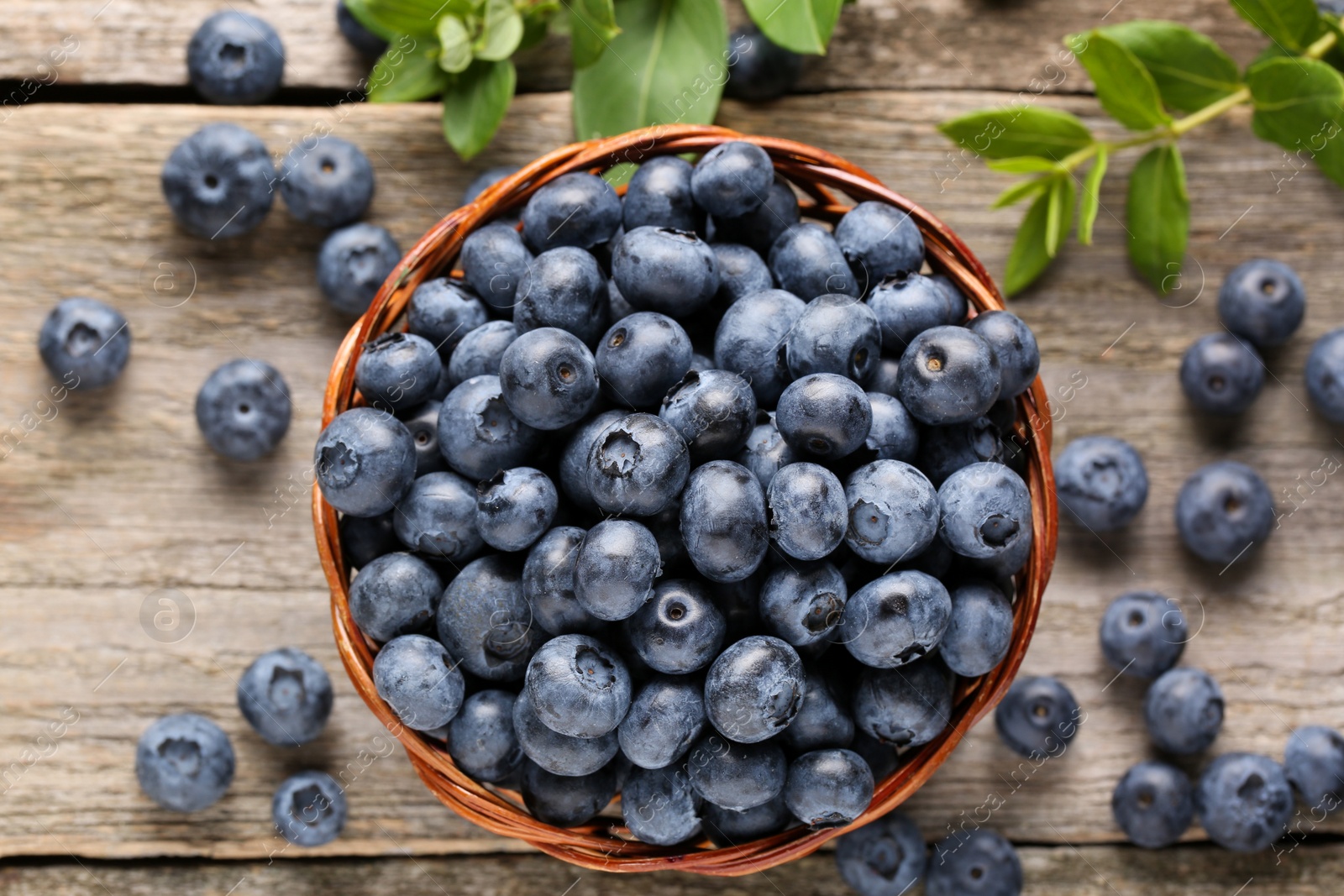 Photo of Tasty fresh blueberries on wooden table, flat lay