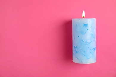 Photo of Alight wax candle and space for text on color background