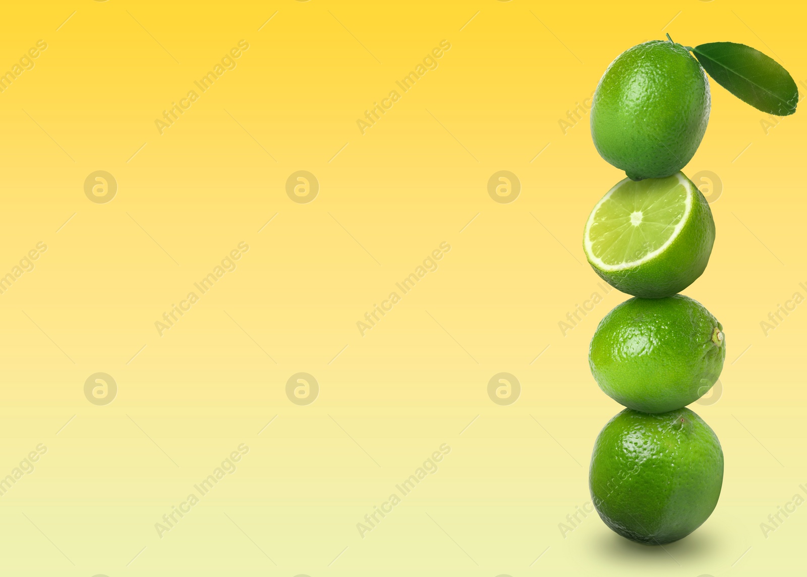 Image of Stacked whole and cut limes on yellow background, space for text