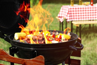 Tasty steak, sausages and vegetables on modern barbecue grill outdoors