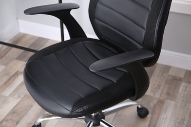 Photo of Modern comfortable office chair in room, closeup