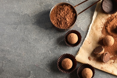Photo of Flat lay composition with chocolate truffles on grey background, space for text