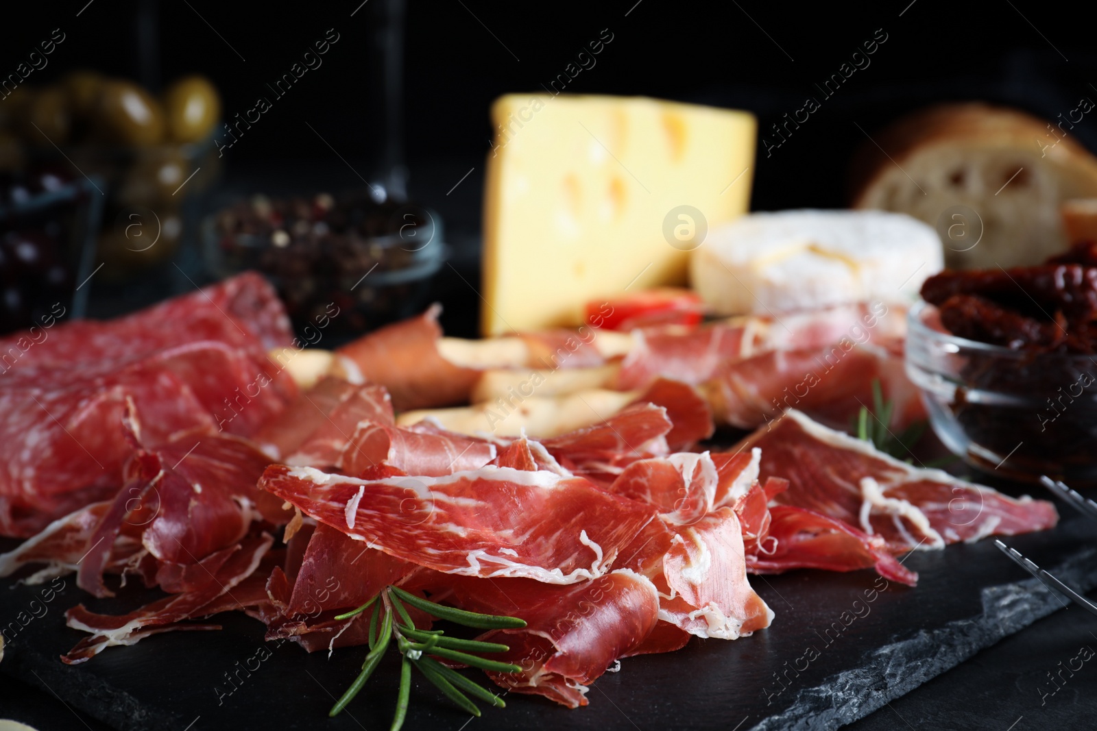 Photo of Tasty prosciutto served on grey table, closeup