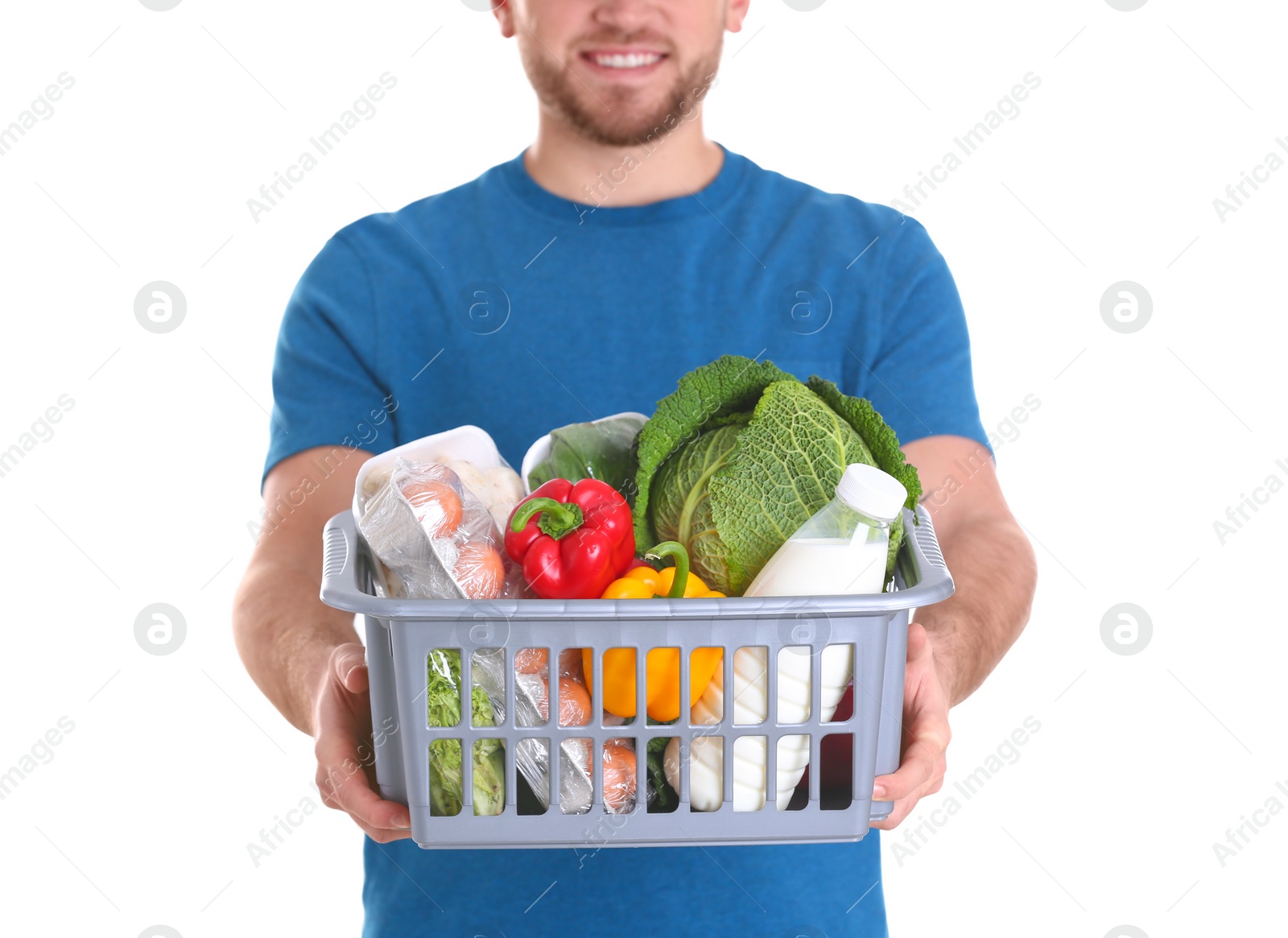 Photo of Delivery man holding plastic crate with food products on white background, closeup