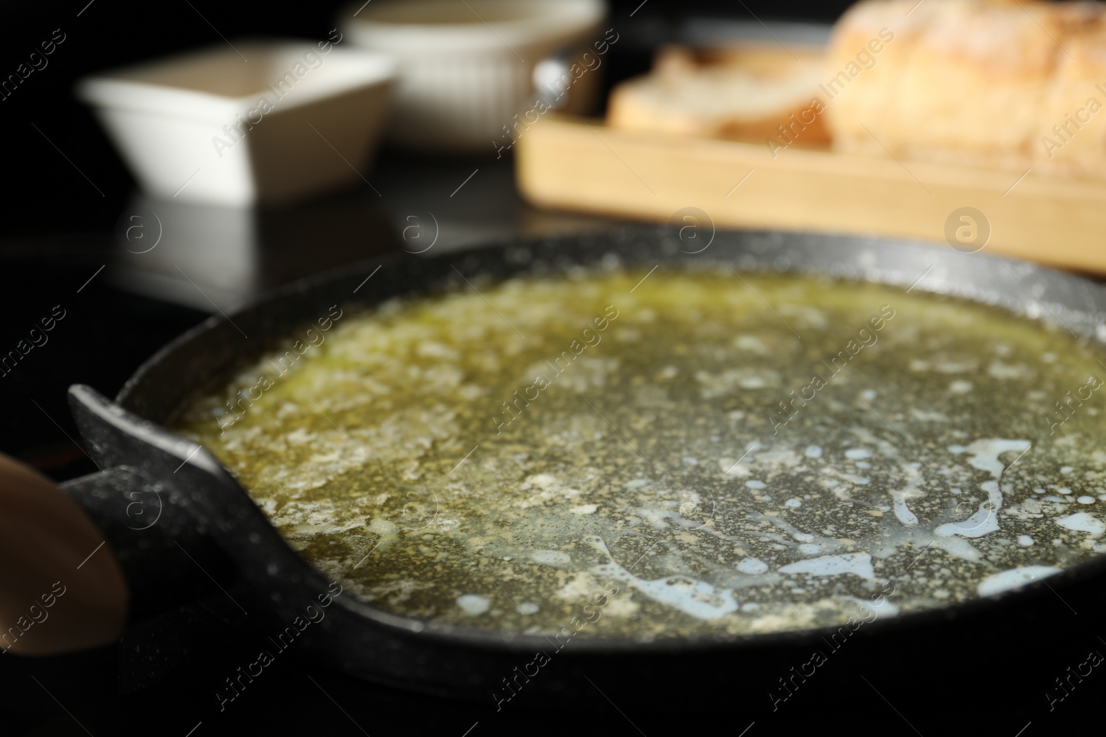 Photo of Melted butter in frying pan on table, closeup