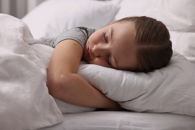 Photo of Little girl suffering from headache in bed