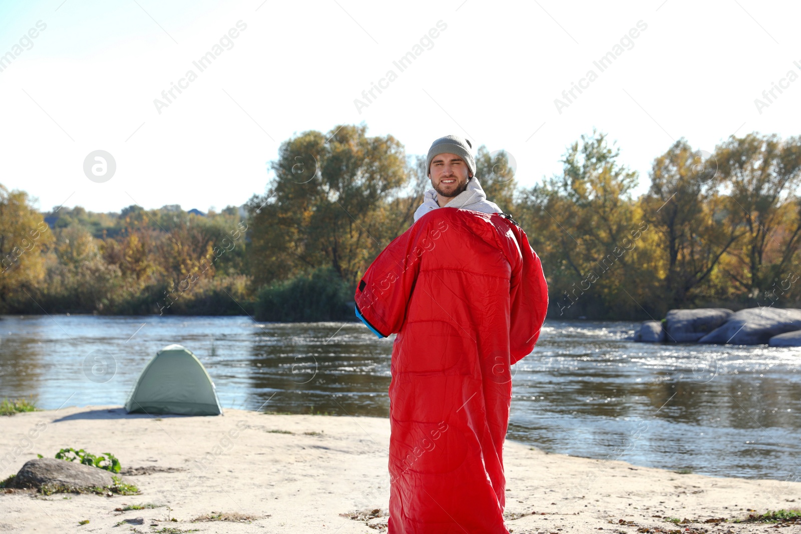 Photo of Male camper in sleeping bag on wild beach