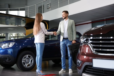 Photo of Customer and salesperson shaking hands in car dealership