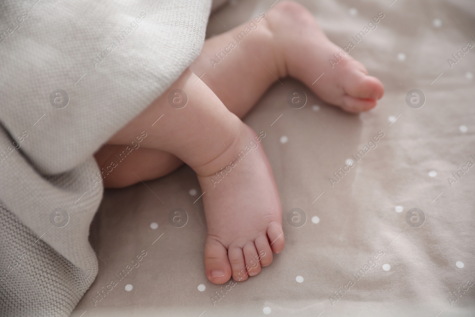 Photo of Cute little baby lying in bed, closeup of feet. Bedtime