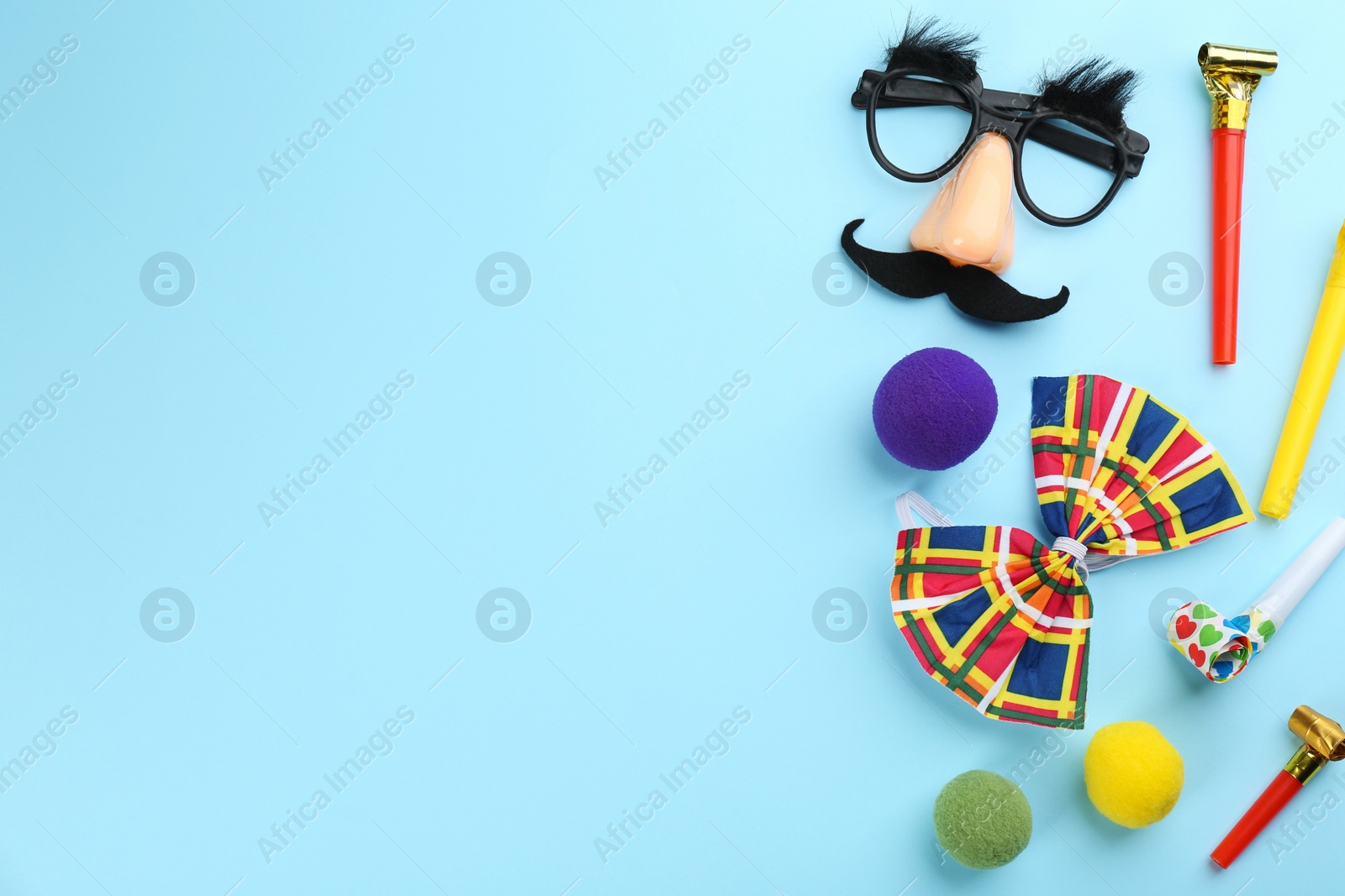 Photo of Flat lay composition with clown accessories on light blue background. Space for text