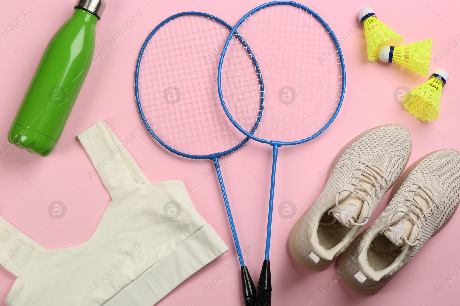 Photo of Flat lay composition with rackets and shuttlecocks on pink background. Playing badminton
