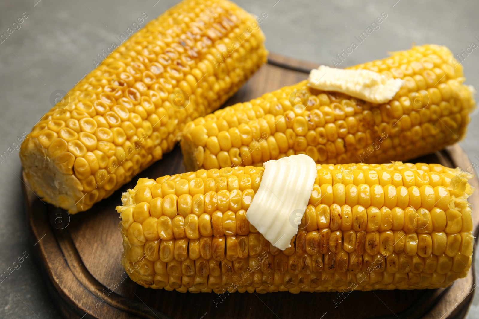 Photo of Delicious grilled corn with butter on table, closeup