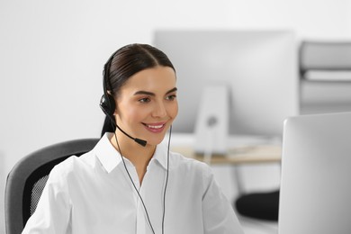 Hotline operator with headset working on computer in office