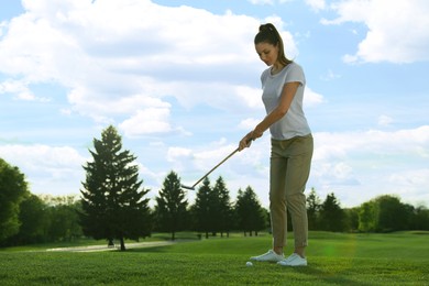 Photo of Beautiful woman playing golf on green course, space for text