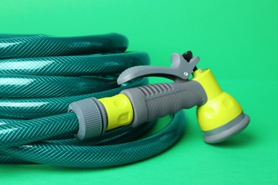 Photo of Watering hose with sprinkler on green background