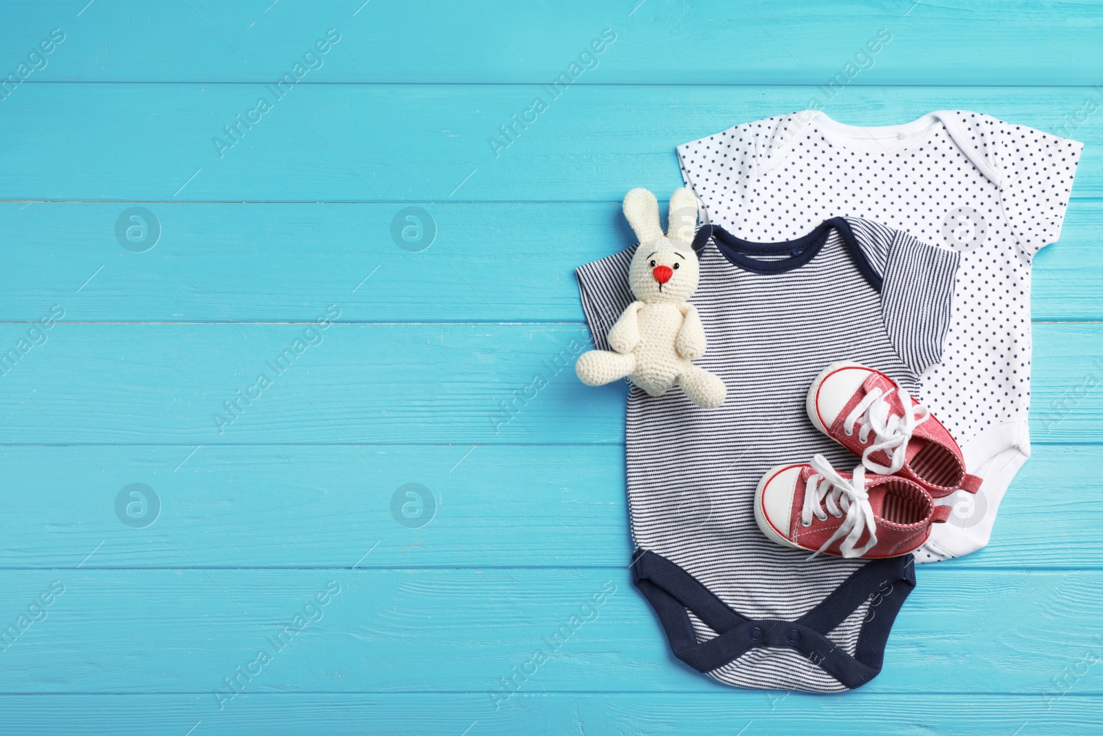 Photo of Flat lay composition with clothes and space for text on wooden background. Baby accessories