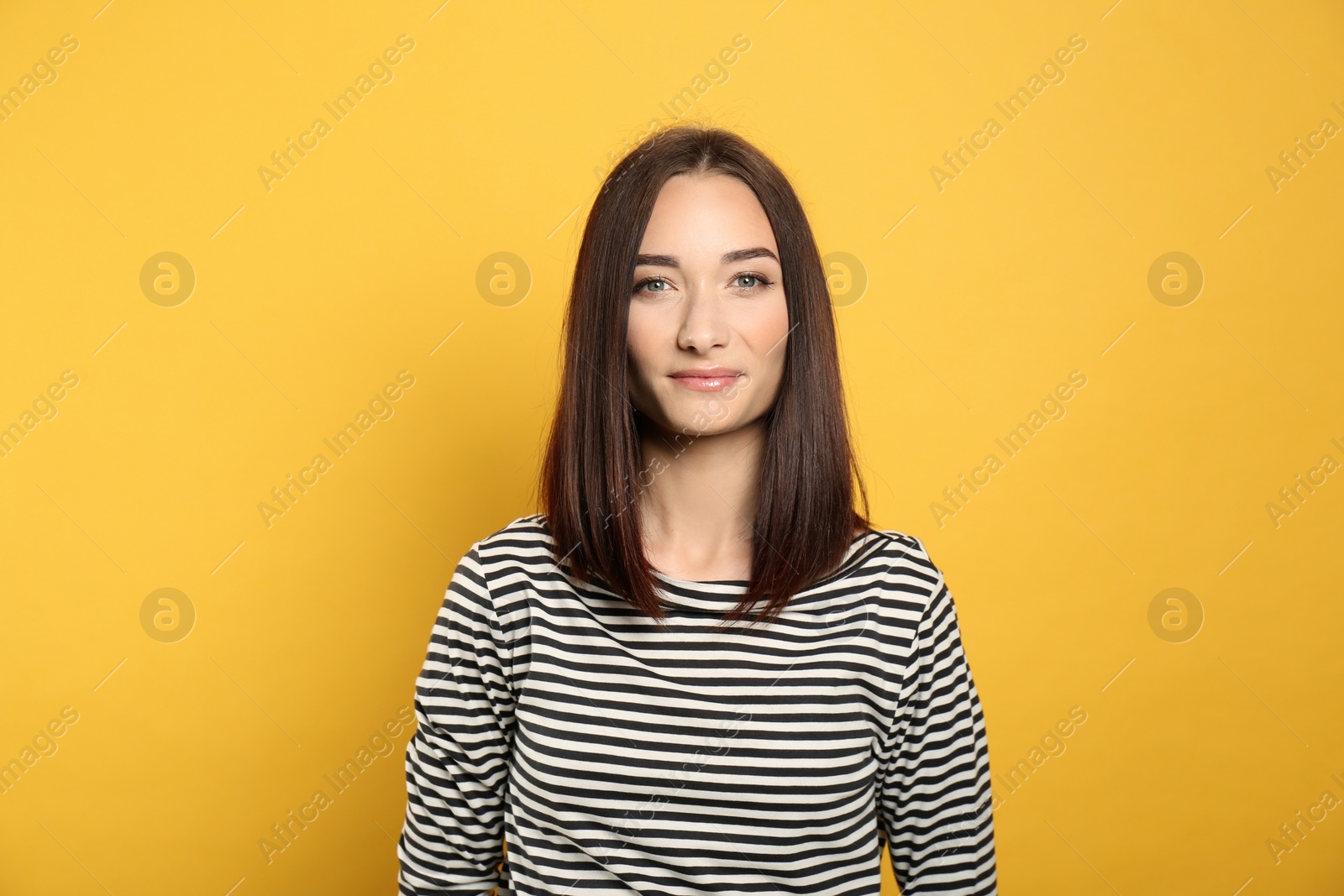 Photo of Portrait of pretty young woman with gorgeous chestnut hair on yellow background
