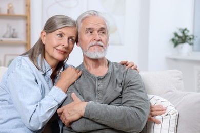 Portrait of affectionate senior couple at home, space for text