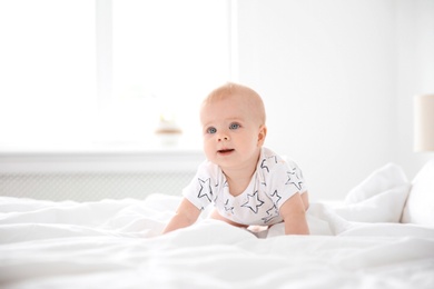 Photo of Cute little baby crawling on bed at home