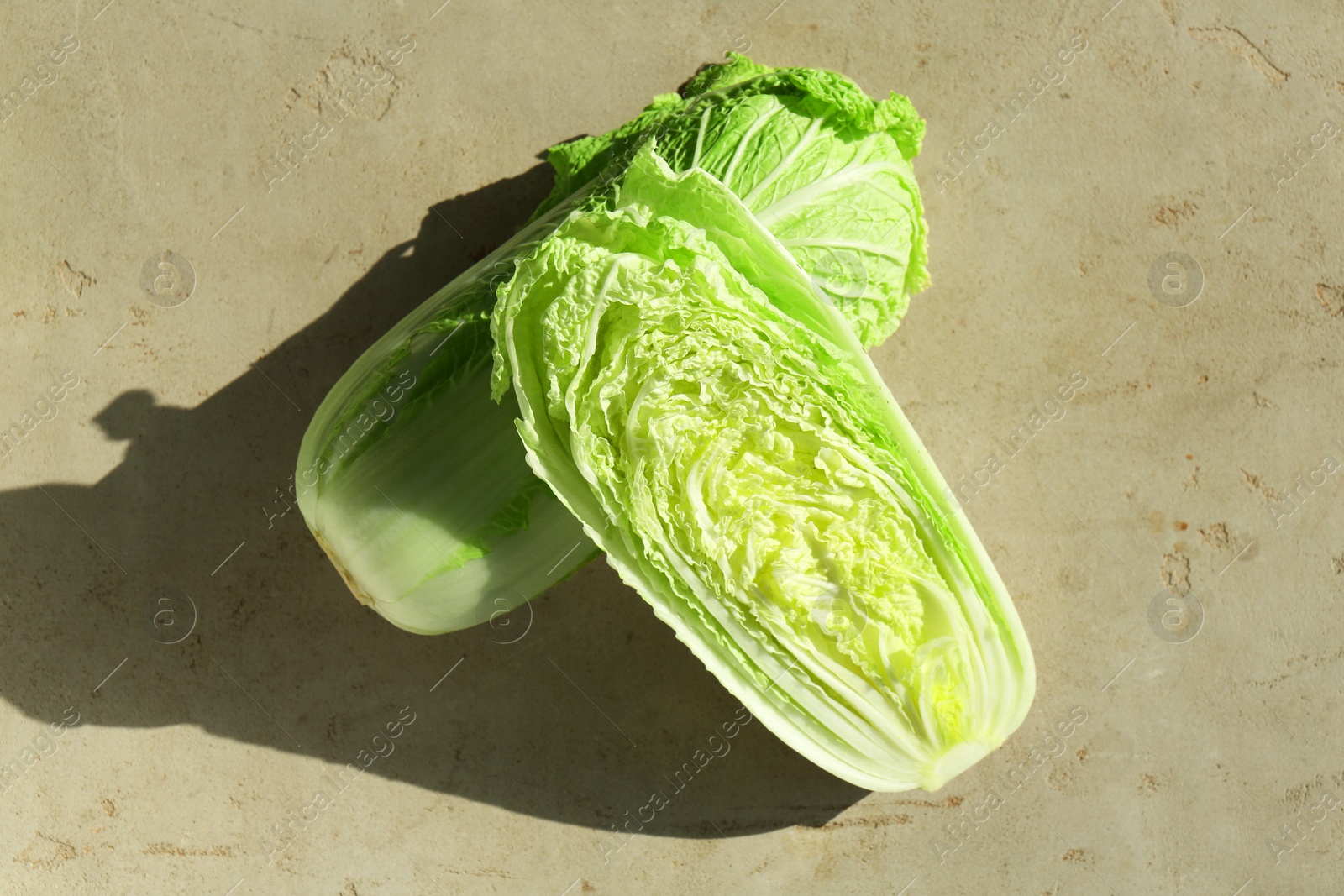 Photo of Fresh ripe Chinese cabbages on textured gray table, top view