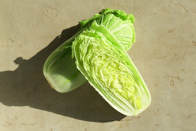 Fresh ripe Chinese cabbages on textured gray table, top view