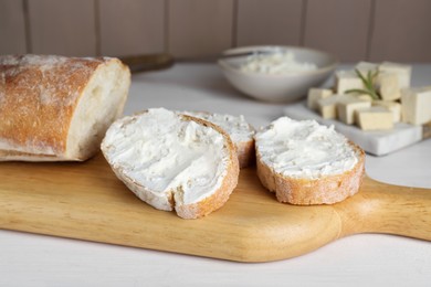 Photo of Slices of baguette with tofu cream cheese on white wooden table