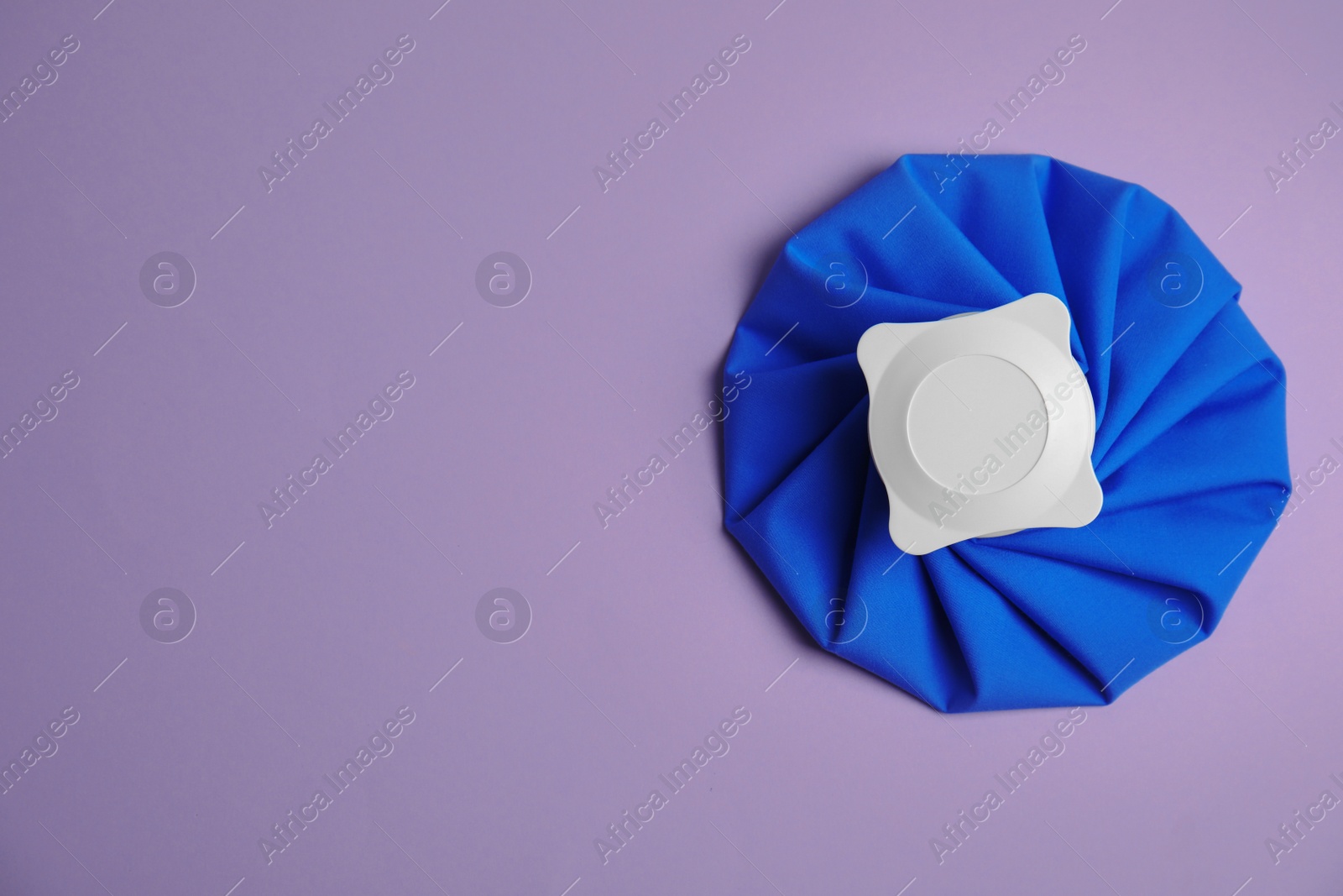 Photo of Ice pack on lilac background, top view. Space for text