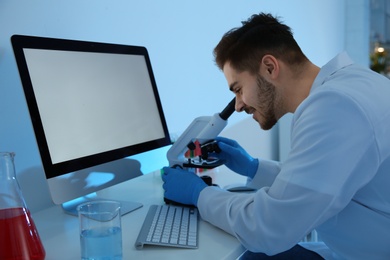 Medical student working with microscope in modern scientific laboratory