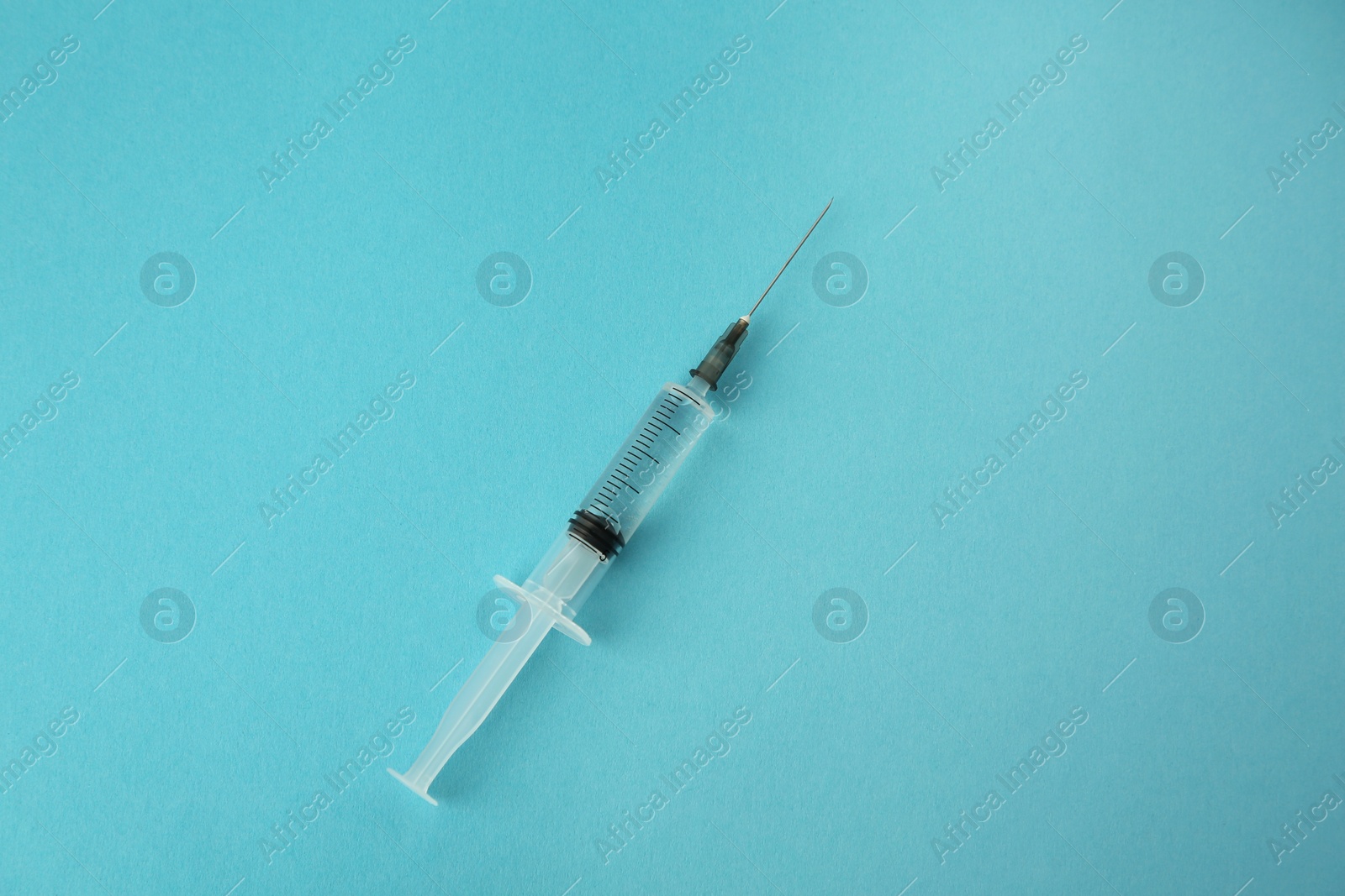 Medical syringe on light blue background, top view Photo of Medical syringe on light blue background, top view