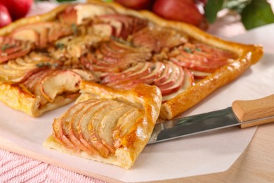 Freshly baked apple pie with knife on table, closeup