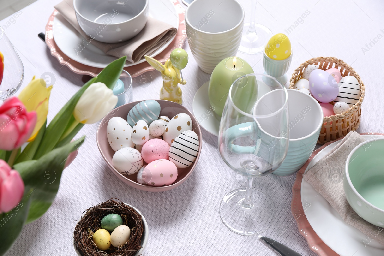 Photo of Festive table setting with painted eggs. Easter celebration