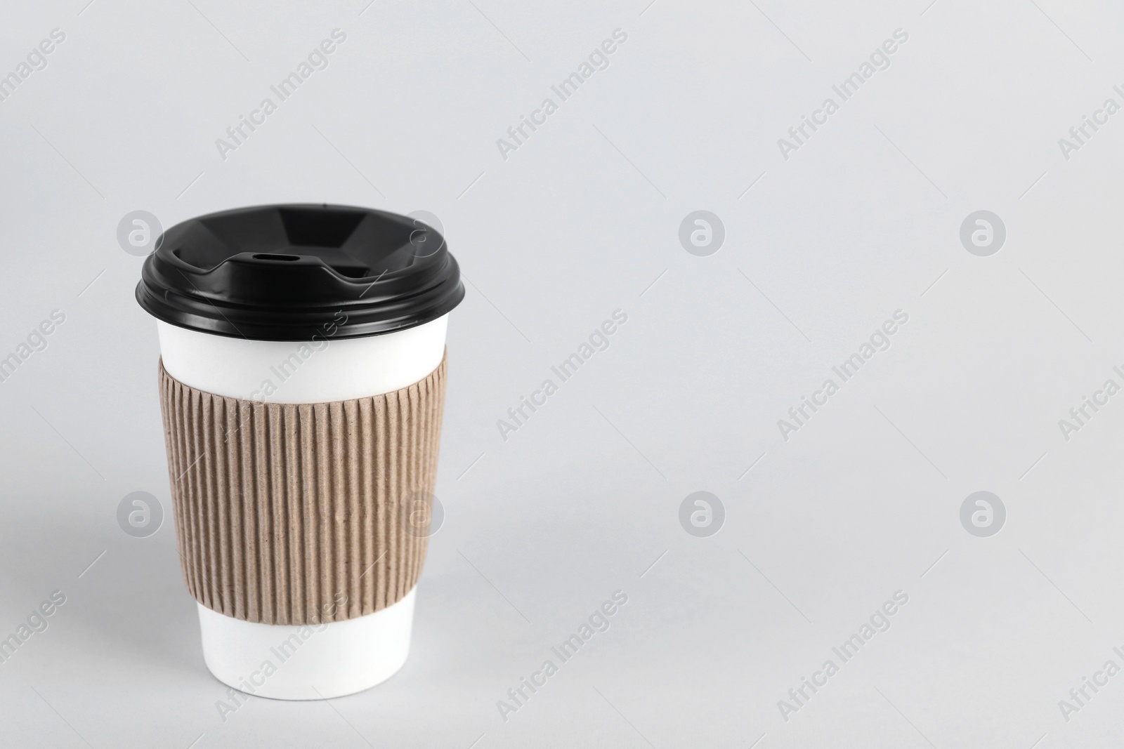 Photo of Paper cup with plastic lid on light background, space for text. Coffee to go