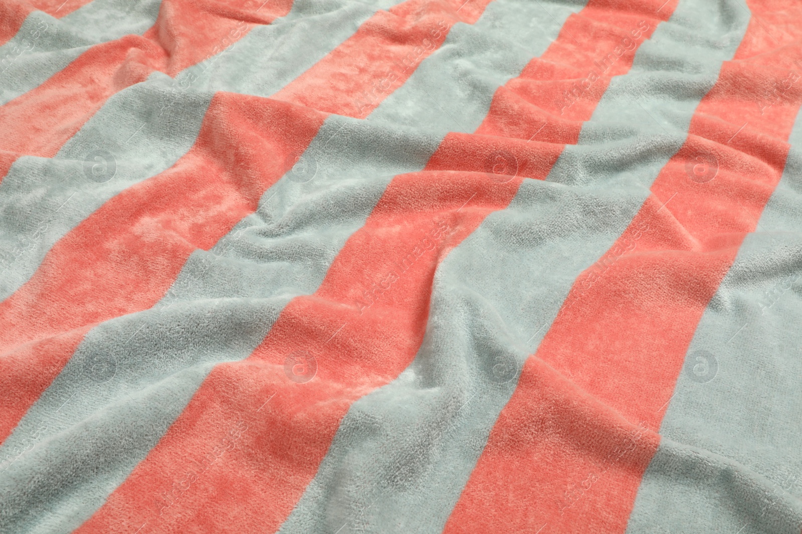 Photo of Crumpled striped beach towel as background, closeup view