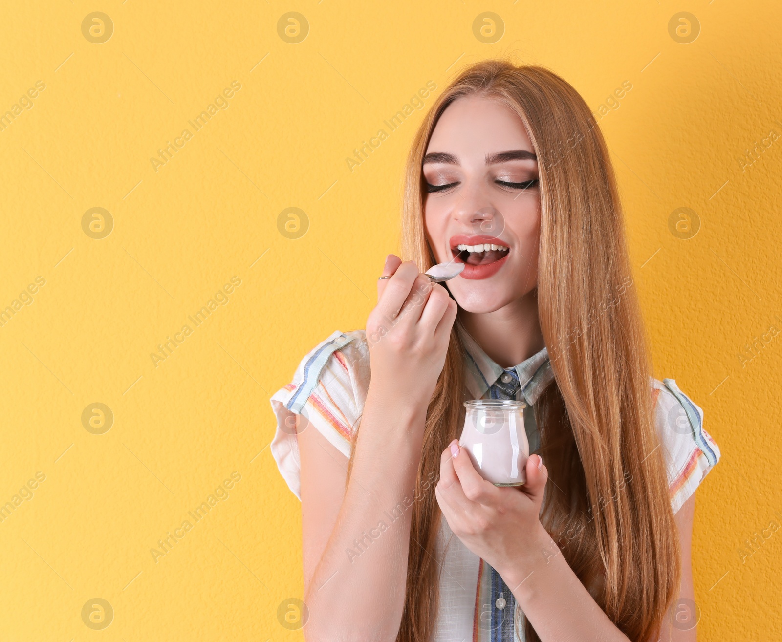 Photo of Young woman with yogurt on color background