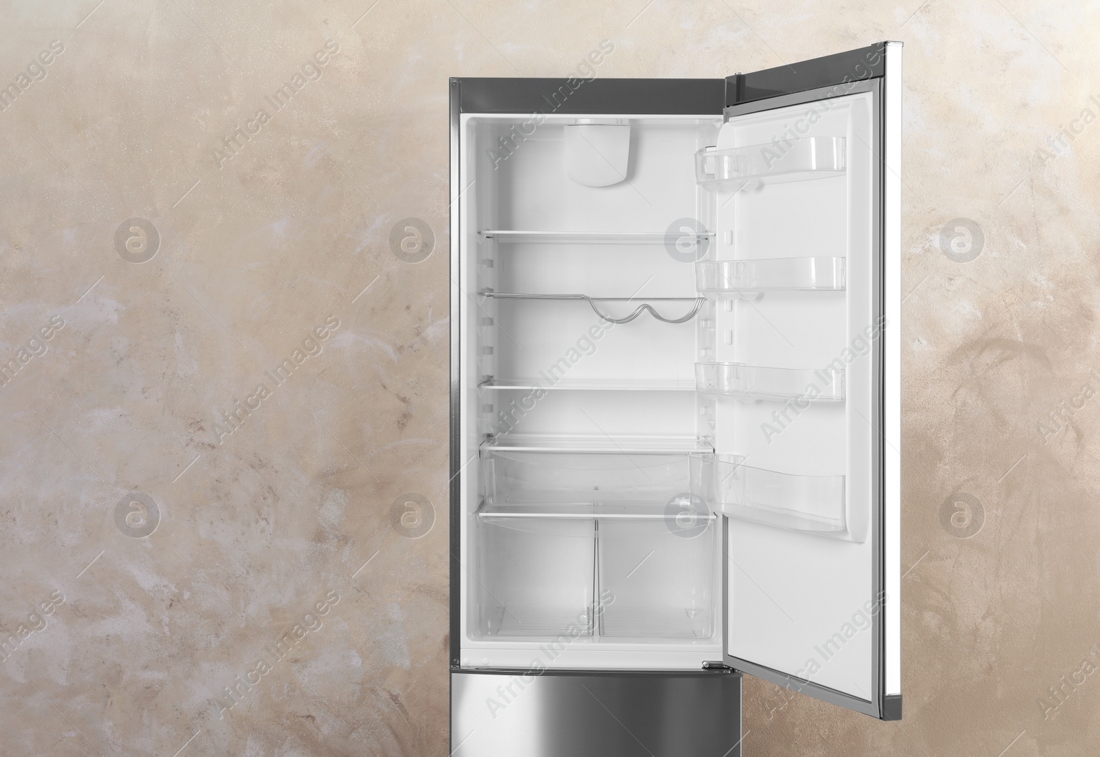 Photo of Open refrigerator with empty shelves on grey background. Space for text