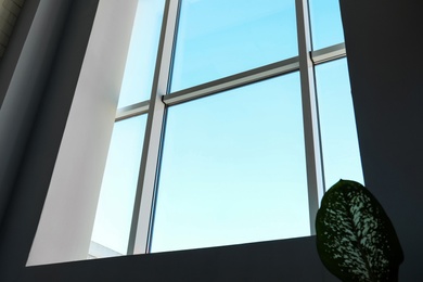 Photo of View of blue sky through large modern window indoors