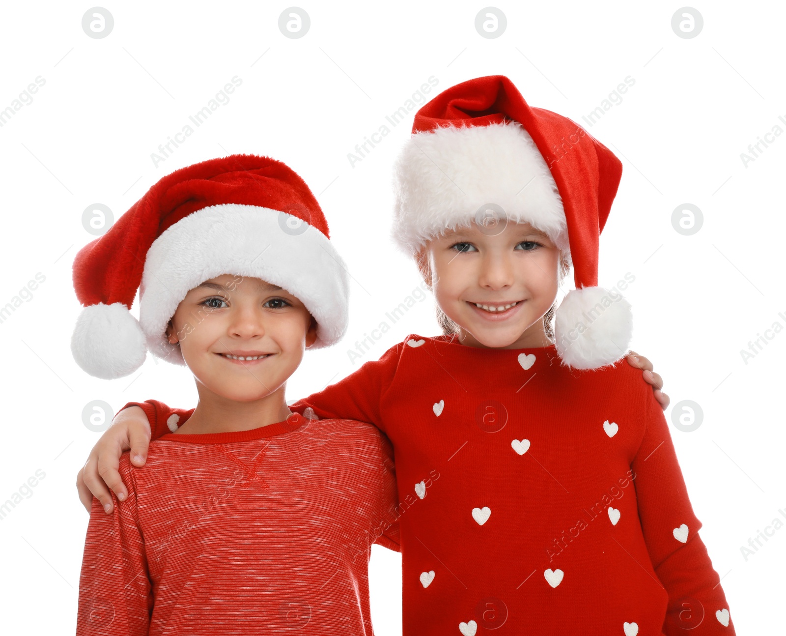 Photo of Cute little children wearing Santa hats on white background. Christmas holiday