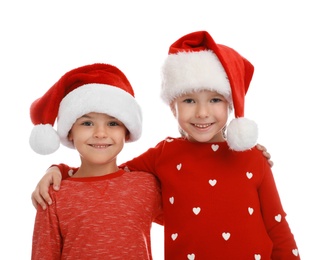 Photo of Cute little children wearing Santa hats on white background. Christmas holiday
