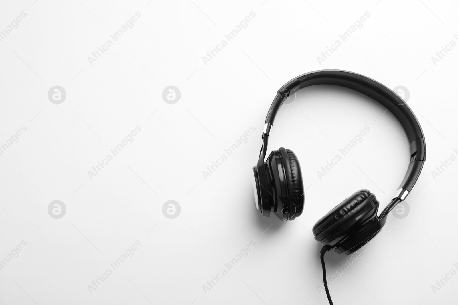 Photo of Stylish modern headphones with earmuffs on white background, top view. Space for text