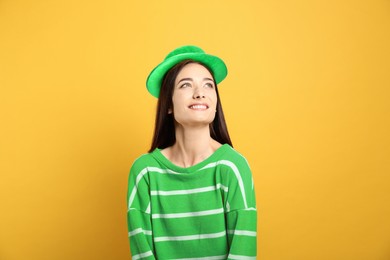 St. Patrick's day party. Pretty woman in green leprechaun hat on golden background