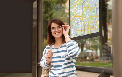 Image of Young woman waiting for public transport at bus stop