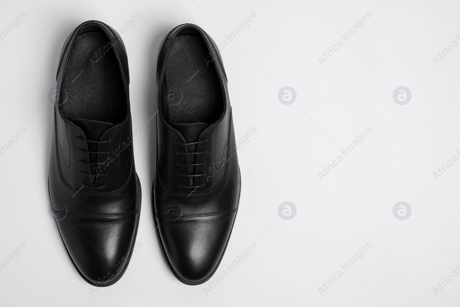 Photo of Pair of leather men shoes on white background, top view. Space for text