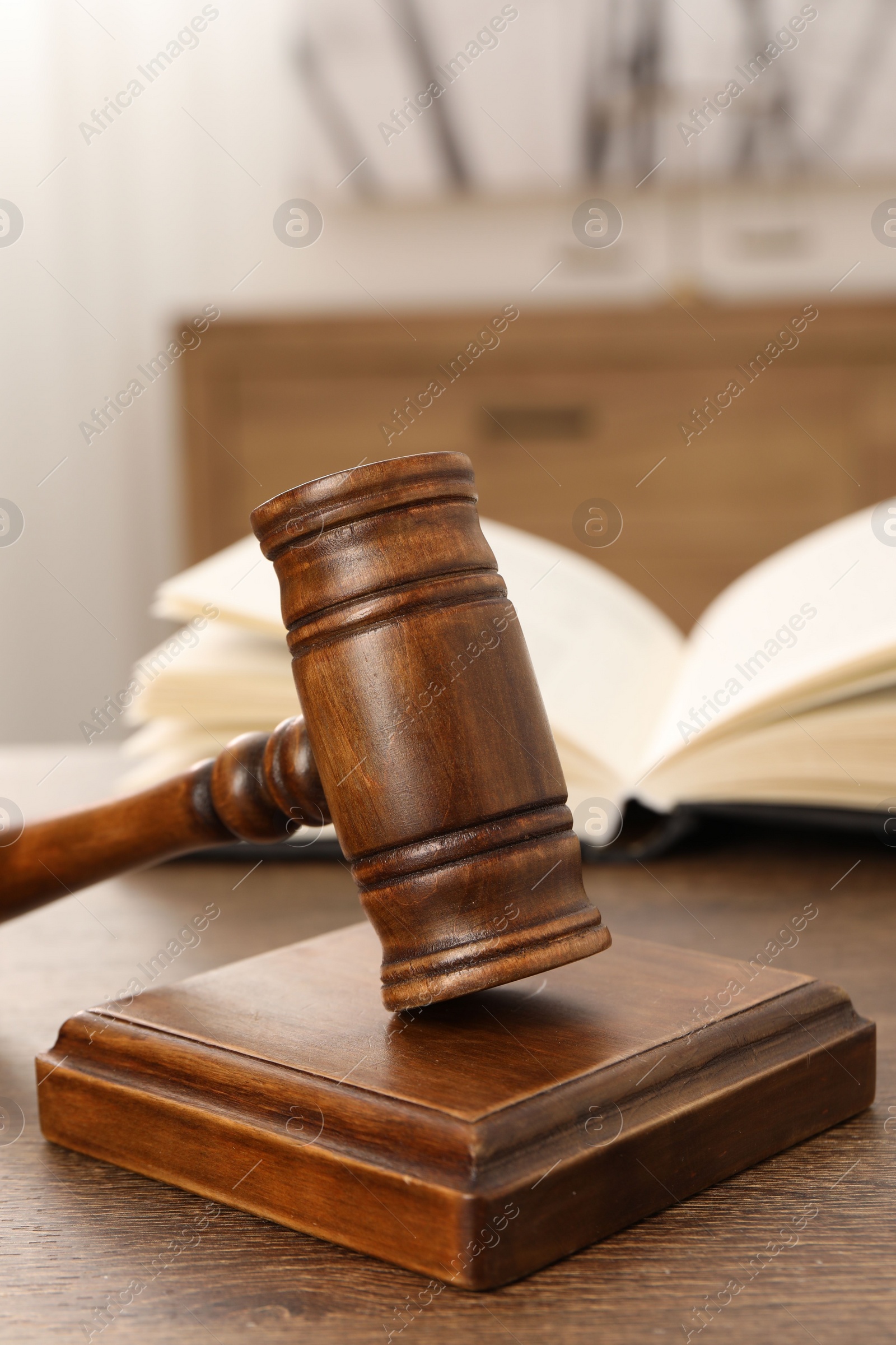 Photo of Wooden gavel and sound block on table indoors, closeup